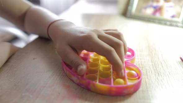 Little Girl Playing with Silicone Toy Antistress Pop It alt