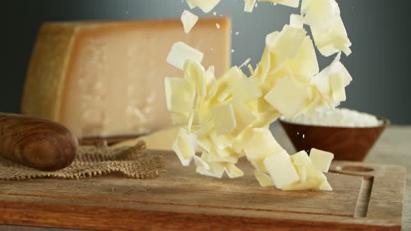 Super Slow Motion Shot of Parmesan Shavings Falling on Wooden Board at 1000 Fps alt