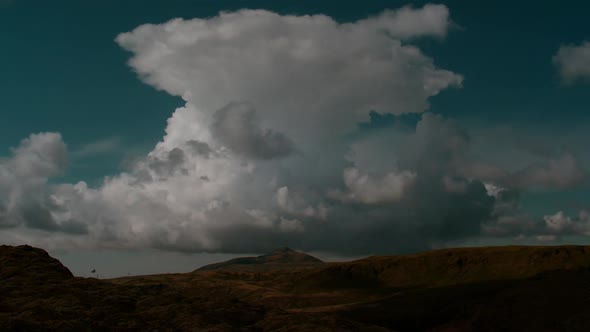 dramatic iceland landscape,fast moving clouds, wide shot with volcanic peak in a distance, timelapse