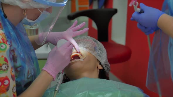 Woman Dentist Treating Teeth To Woman Patient in Clinic, Oral Hygiene with a Special Solution alt