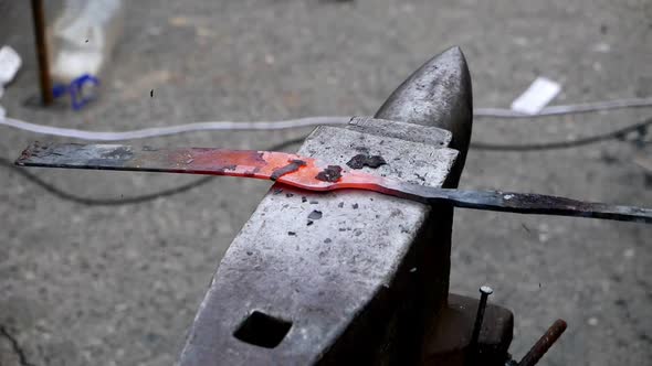 Blacksmith Forging a Metal Detail with Hammer