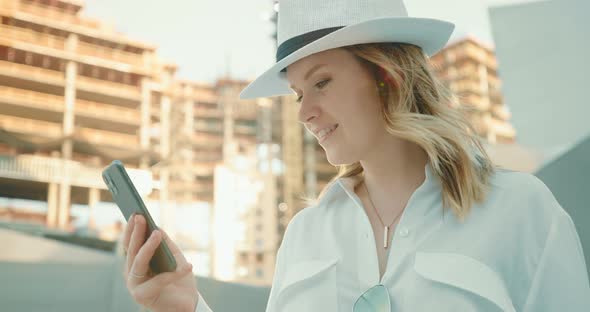 Smiling Woman with Smartphone Slow Motion  Building Construction on Background alt