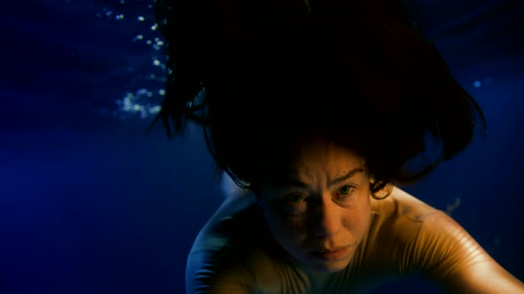 Woman is Drowning in Dark Blue Water of Sea or Ocean Closeup Portrait Suffering Face and Stretching alt