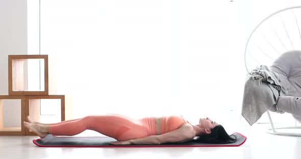 Woman doing abdominal exercises on mat at home.