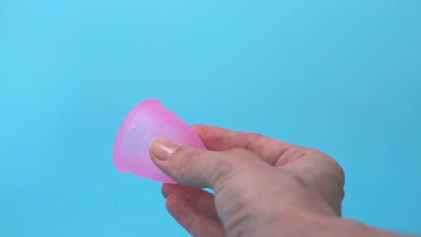 Pink Menstrual Cup Closeup on a Blue Background