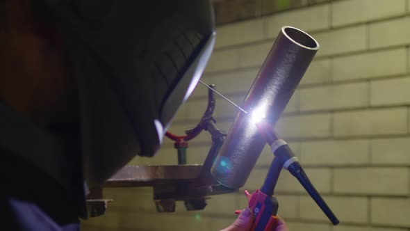 Metal Welder Working with Arc Welding Machine to Weld Steel at Factory While Wearing Safety alt