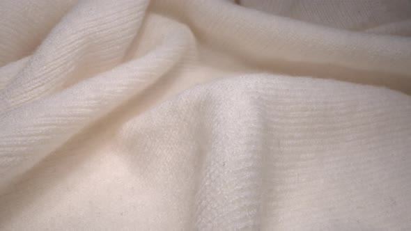 Cozy sheep wool cream-colored fabric texture in macro. Handcraft knitting woolen sweater alt