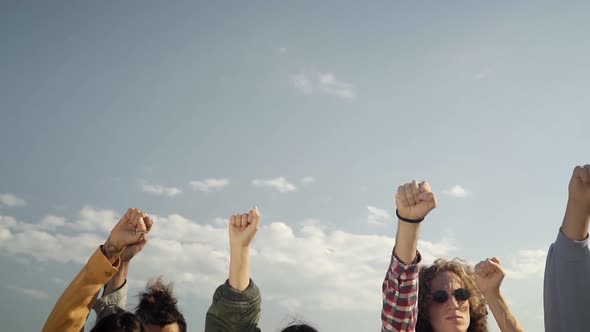 Group of People Hands Raised in a Protest Participating in a Nonviolent March alt