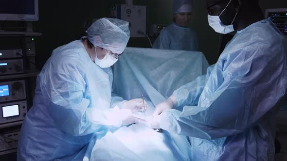 Female surgeon finishing operation