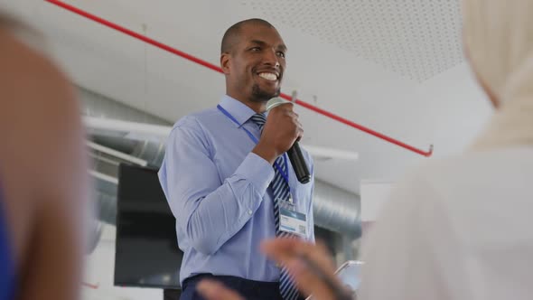 Male speaker addressing applauding audience at a business seminar alt