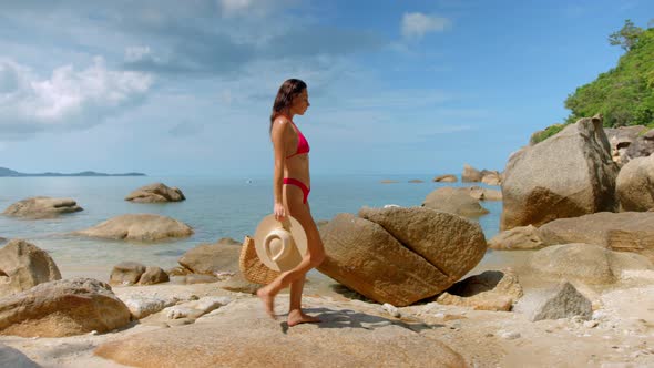 Female on Vacation She Walking on the Beach of Tropical Island Holds a Bag and a Hat in the Hands alt