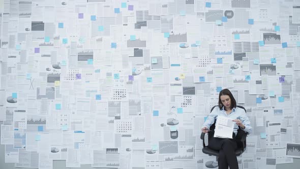 Businesswoman analyzing financial data on a wall