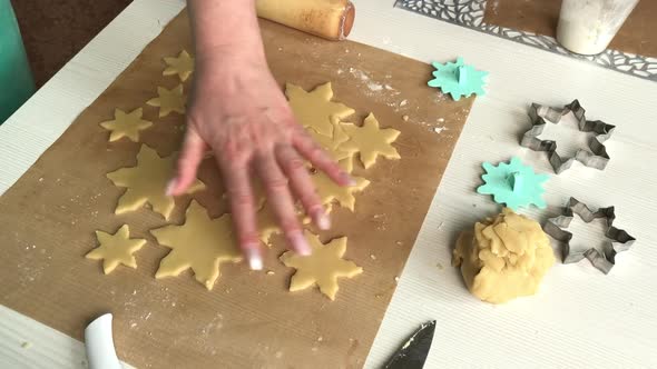 A Woman Works With Snowflake Cookie Dough. alt