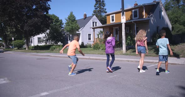Kids walking across street one boy running alt