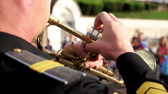 A Wind Instrument  a Unrecognizable Military Man is Playing Trumpet Closeup alt