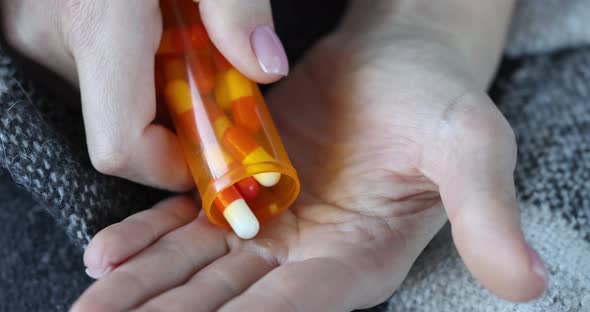Person Pours Pills on Arm for Treatment Closeup alt