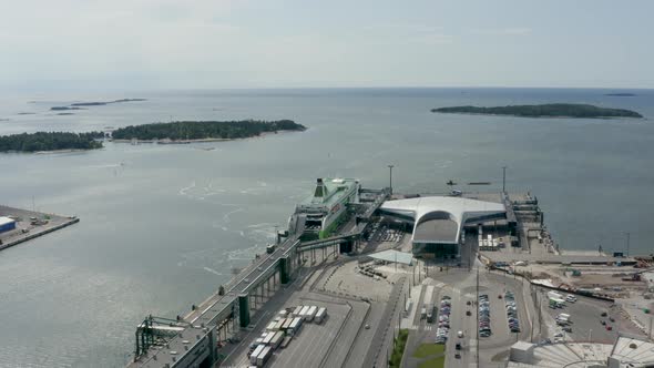 Aerial reverse shot above port in Helsinki, Finland with large ship at dock. alt
