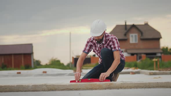 The Young Engineer Checks the Accuracy of the Work on the Construction of the Foundation alt