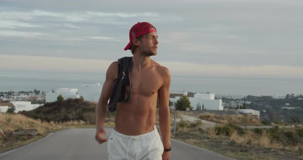 Slim Man In Backwards Cap On Road alt