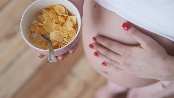 Pregnant Woman Eating Cornflakes with Milk