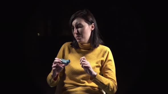 Face Young Woman Is Sick with Asthma Using an Asthmatic Inhaler Closeup on a Black Background alt