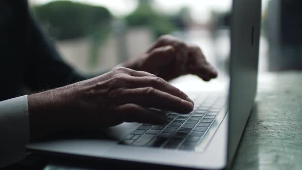 Elderly Man Typing on Laptop