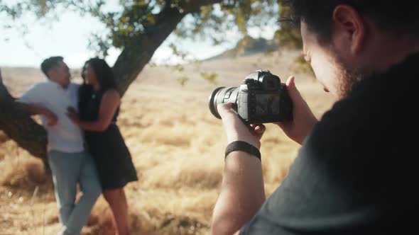 Back Close Up View Professional Photographer Making Pictures of Romantic Couple alt