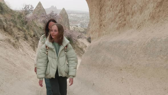 Two Female Tourists Walking Along Rock Formations in Cappadocia Turkey
