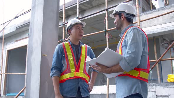 Young Asian engineers and caucasian engineer colleagues at site inspector and discuss together alt