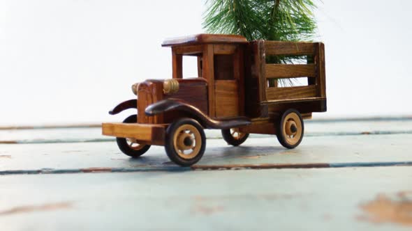 Toy tempo carrying christmas fir on wooden plank alt