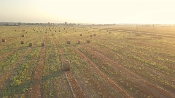 Harvesting, Flying Over The Cleared Field. Aerial shot, Combine Harvested Fields With Baling Hay alt