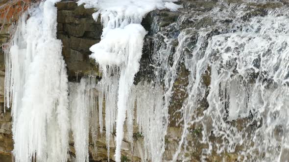 Flowing Water Cascading Over Water Past Ice At Niagara Escarpment. Slow Pan Right alt