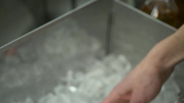 Barman Takes Pieces of Ice To Make Drinks at Bar