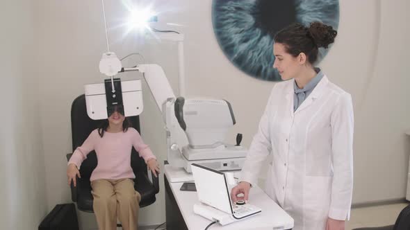 Little Girl Doing Eye Checkup In Modern Clinic alt