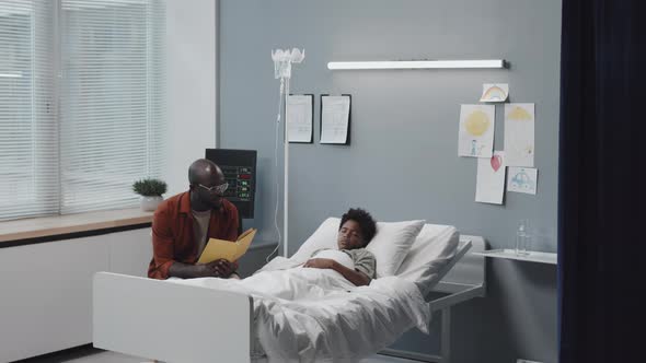Father Reading to Boy in Hospital alt