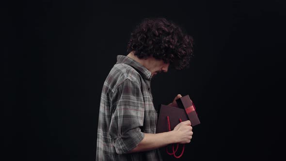 The Profile of a Boy with a Gift in His Hand He Opens It and Shouts Wow Being Pleasantly Surprised alt