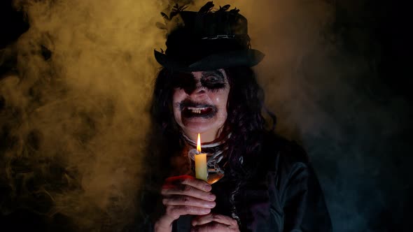 Frightening Creepy Senior Woman with Halloween Witch Makeup Looking at Candle Conjure Hex Wiz alt