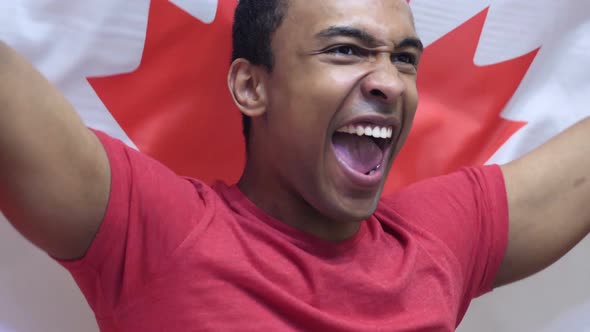 Canadian Fan Celebrating while Holding the Flag of Canada alt