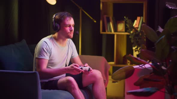 Young Man Gamer Wearing Headphones with Microphone Playing Video Game on Tv Gesturing Dislike alt