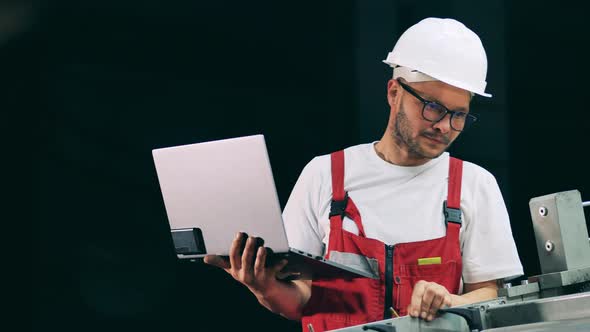 Engineering Specialist with a Laptop is Observing a Conveyor alt