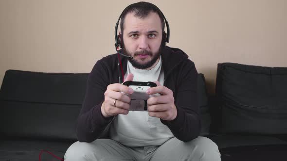 Serious Gamer with Headset and Joystick Participate in Online Gaming Competition