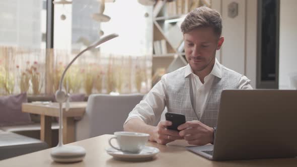 Businessman sitting and working in a cafe. Man using computer. alt