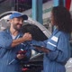 Team of mechanic with man and woman holding tablet computer in uniform talking and handshake. - VideoHive Item for Sale