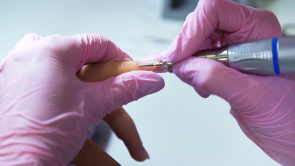 Hands in Gloves Removing Cuticles with Polish Machine alt