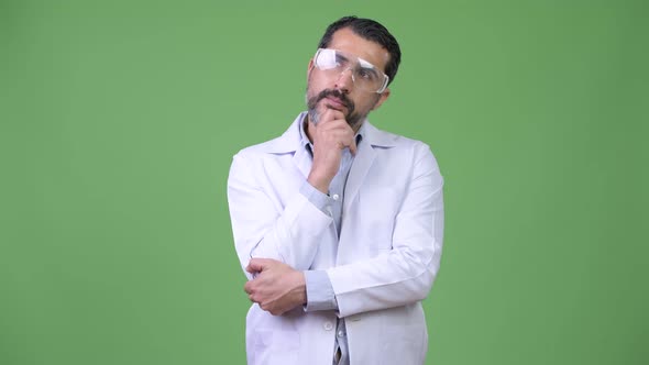 Happy Persian Bearded Man Doctor Wearing Protective Glasses While Thinking