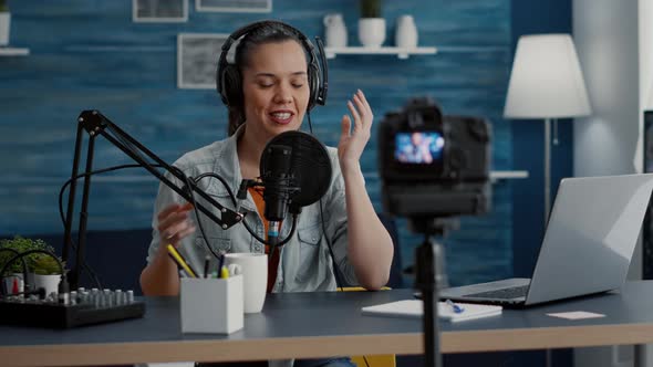 Creative Content Creator Putting Headphones on While Recording Vlog alt