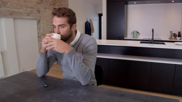 Guy In Grey Drinking In Modern Apartment
