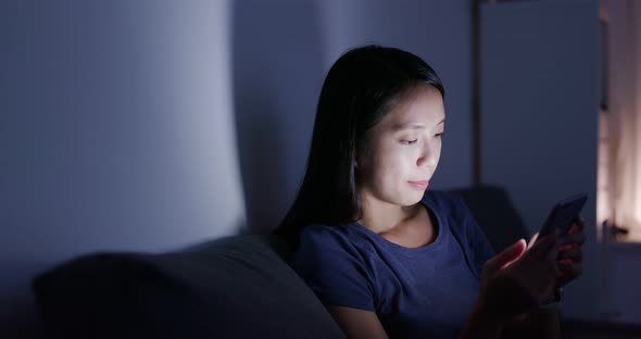 Woman use of cellphone at home in the evening alt