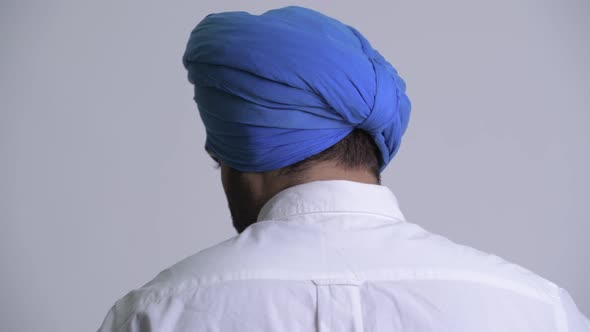 Closeup Rear View of Young Bearded Indian Sikh Man Looking Back alt