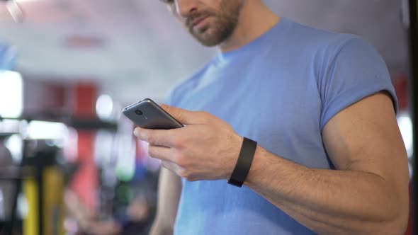 Athlete Launching Application on Smartphone to Synchronize With Fitness Bracelet alt